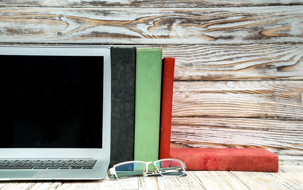 A split image comparing traditional textbooks with modern digital learning tools, such as laptops and tablets, emphasizing the changing landscape of educational materials covered by the AOTC.